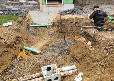 Excavation crew installing underground utilities at a residential property in the Concord, NH area.